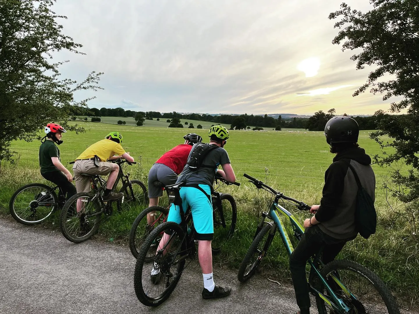 Explorers pausing to enjoy the sunset on a countryside bike ride