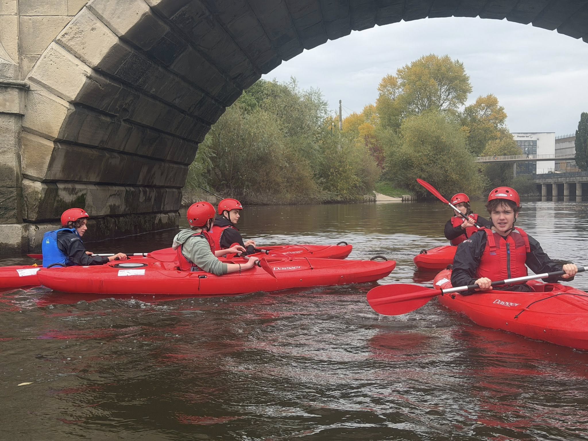 Triffid Explorers kayaking under a bridge on the river in Ludlow